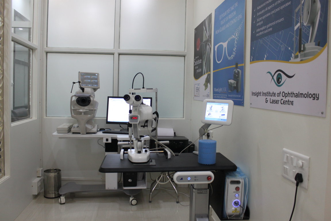 Pre-LASIK biometry and tomography workstation at Insight Institute with the WaveLight diagnostic suite, refraction slit-lamp and patient education posters